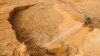 FILE - A laborer hoses water at the site of a rare earth metals mine at Nancheng county, Jiangxi province.