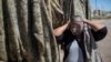 FILE - A vendor shows a mask used by migrants as protection from the low desert night temperatures they face during their treks to the United States, in Sonoyta, in the northern Mexican state of Sonora, April 4, 2017. 