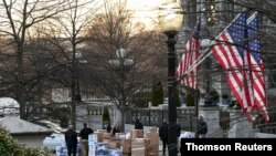 Empleados cargan camiones con las pertenencias de los empleados de la administración saliente en la Casa Blanca, el 14 de enero de 2020.