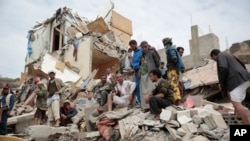 People inspect the rubble of houses destroyed by Saudi-led airstrikes in Sanaa, Yemen, Friday, Aug. 25, 2017. Airstrikes by a Saudi-led coalition targeted Yemen's capital early on Friday, hitting at least three houses in Sanaa and killing at least 14 civi
