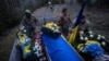 Ukrainian servicemen travel with the coffin of their comrade Vasyl Medviychuk during a funeral ceremony in Krasnyk village, Ukraine, Dec. 28, 2023.