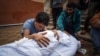 A Palestinian mourns over the body of a relative killed in Israeli strike at the Nasser hospital in Khan Younis on the southern Gaza Strip, Dec. 28, 2023.