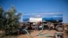 Dimitris Papadakis Jr, turns the valve on a container that is connected to a small generator, to water an olive grove in the village of Nea Silata at Halkidiki peninsula, northern Greece, Aug. 19, 2024. 