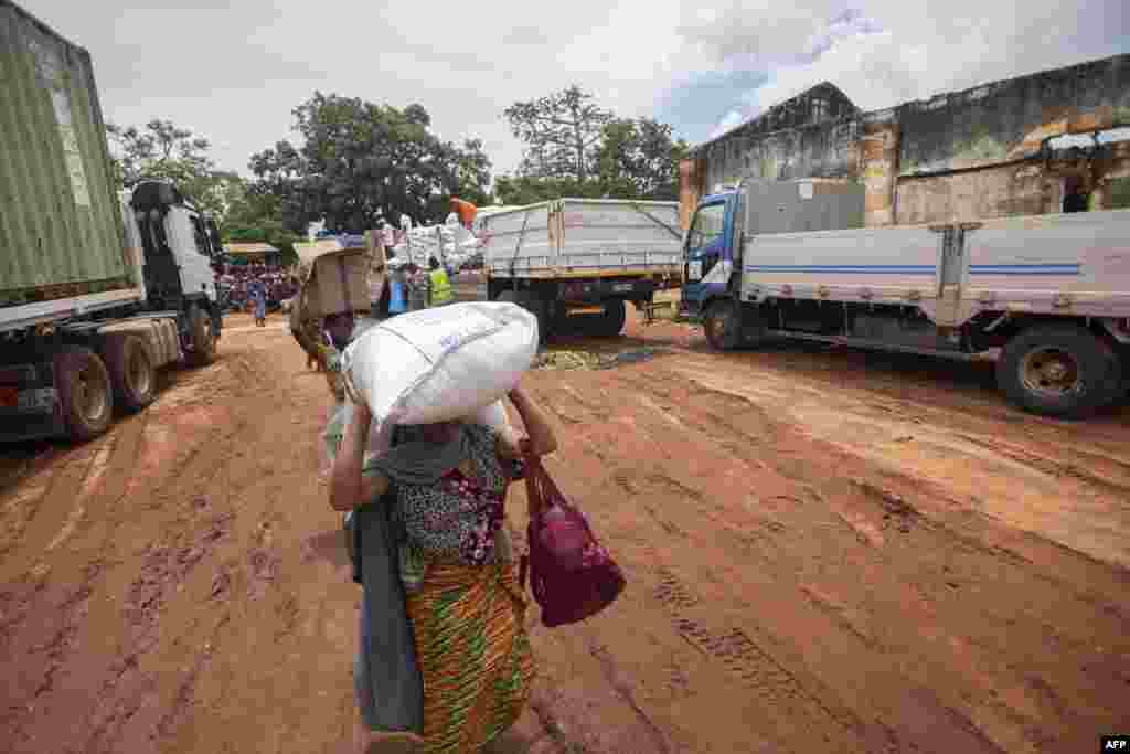  Mulher carrega alimentos distribuídos pelo Programa Alimentar Mundial (PAM) aos deslocados da província de Cabo Delgado, na Escola Tribuna 21 de abril, na vila de Namapa, distrito de Erati, Nampula, Moçambique, a 27 de fevereiro de 2024. 