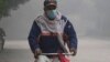 FILE - A cyclist wears mask to head to his work-point as smog envelops the areas of Lahore, Pakistan, Nov. 8, 2023. 