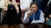 Mantan Perdana Menteri Pakistan Imran Khan, kanan, dan Bushra Bibi, istrinya, di kantor Pengadilan Tinggi Lahore di Lahore, Pakistan, pada 17 Juli. 2023. Keduanya dijatuhi hukuman 14 tahun penjara atas tuduhan korupsi. (Foto: AP)