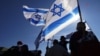Manifestantes con banderas de Israel se congregan frente al Tribunal Supremo para reclamar que la jóvenes de la comunidad ultraortodoxa sean reclutados por el ejército.