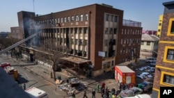 FILE - Medics and emergency staff work at the scene of a deadly blaze in downtown Johannesburg, Aug. 31, 2023. 