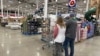 ARCHIVO - Compradores revisan los productos en un almacén de Costco el domingo 25 de febrero de 2024 en Sheridan, Colorado. 