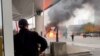 A Customs and Border Protection officer watches as a vehicle burns at the Rainbow Bridge U.S. border crossing with Canada, in Niagara Falls, New York, Nov. 22, 2023 in a still image from video.