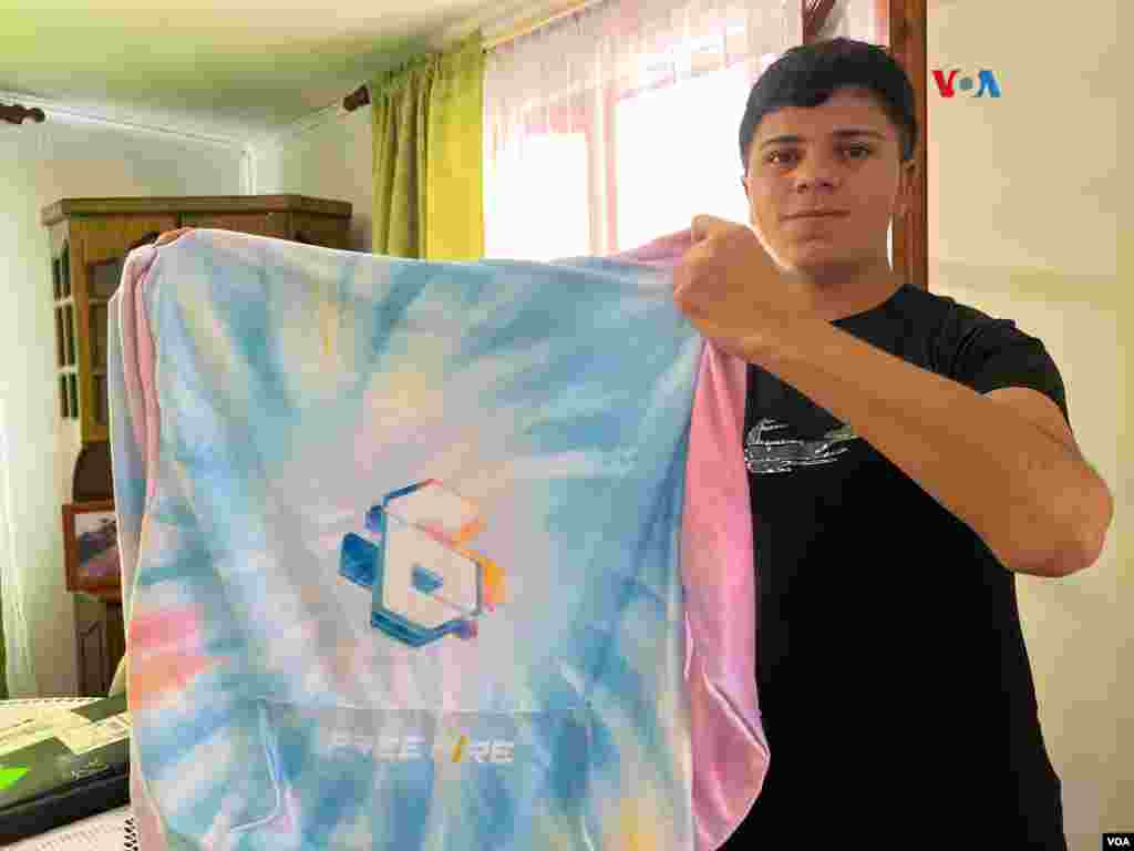 Héctor Carrasco levanta una sudadera regalada por la compañía del videojuego Free Fire a su abuela, Mami Nena, en el sexto aniversario de la creación del juego en línea.