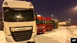 FILE - Ukrainian truck drivers wait to cross from Poland back into Ukraine in Korczowa, Poland, on Dec. 7, 2023. 