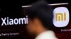 FILE - A man walks past a logo of Xiaomi, a Chinese manufacturer of consumer electronics, outside a shop in Mumbai, India, May 11, 2022.