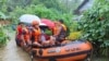 In this photo provided by the Philippine Coast Guard, rescuers use a rubber boat as they evacuate residents to higher grounds following floods due to a tropical storm in Allen, Northern Samar province, Philippines, Sept. 1, 2024.