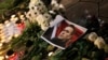 A portrait of Russian opposition leader Alexey Navalny is placed next to candles and flowers as people attend a memorial event for Navalny in front of the Russian embassy in Sofia, Bulgaria, Feb. 16, 2024. 