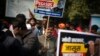 FILE - An opposition Congress party worker holds a placard during a protest accusing Prime Minister Narendra Modi's government of using military-grade spyware to monitor political opponents, journalists and activists, in New Delhi, India, Feb. 2, 2022.