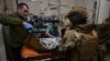 FILE - Ukrainian military medics treat a wounded Ukrainian serviceman at a stabilisation point near Bakhmut, Donetsk region, on Feb. 9, 2024,