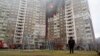 Seorang petugas penegak hukum berdiri di samping sebuah bangunan tempat tinggal, rusak akibat serangan rudal di Kyiv, Ukraina, pada 7 Februari 2024. (Foto: AFP)