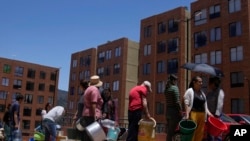 ARCHIVO - Residentes hacen fila para recoger agua de un camión durante el racionamiento de agua en La Calera, en las afueras de Bogotá, Colombia, el 16 de abril de 2024. 