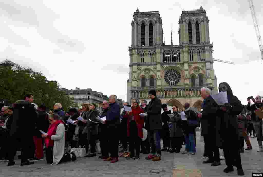 La gente asiste a una procesión del &quot;Via Crucis&quot; del Viernes Santo cerca de la Catedral de Notre-Dame de París en París, Francia.
