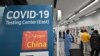FILE - Health workers guide travelers arriving from China at a COVID-19 testing center at Incheon International Airport, west of Seoul on Jan. 3, 2023.