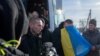 Swapped Ukrainian prisoners of war disembark from a bus after a prisoner exchange for Russian POWs, at an unidentified location in Ukraine, Jan. 31, 2024. (Ukrainian Presidential Press Service/Handout via Reuters)