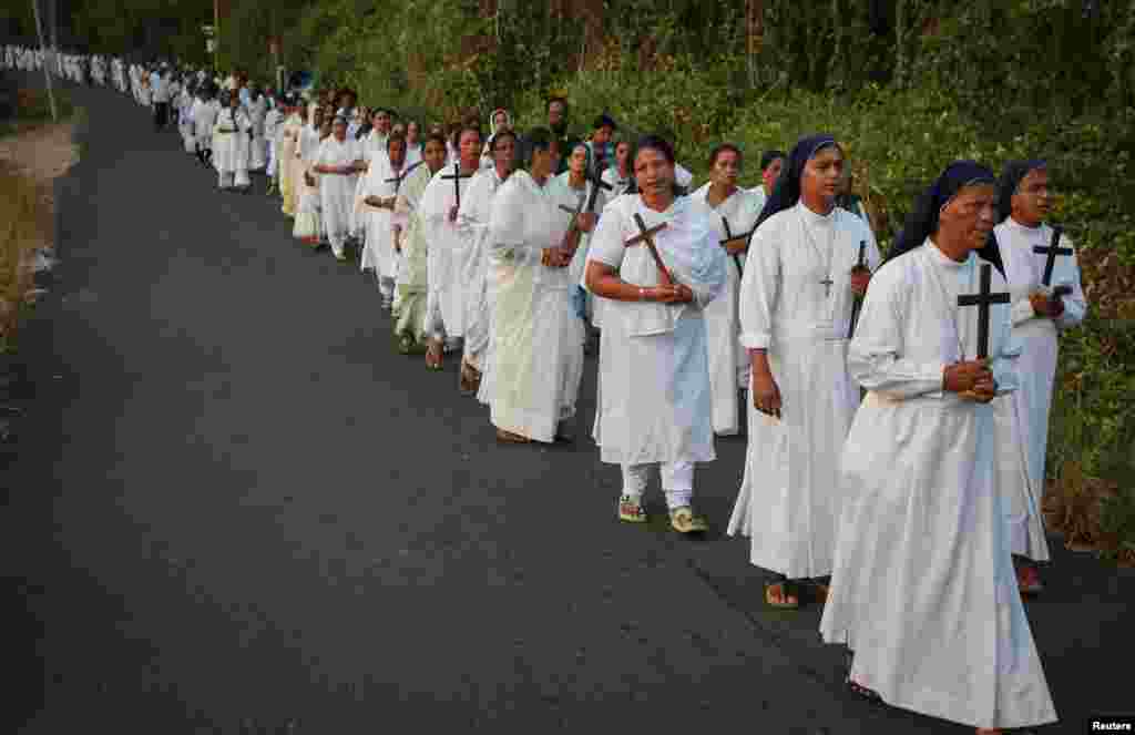 Monjas junto con otros devotos cristianos sostienen cruces de madera mientras participan en la procesión del Viernes Santo en Kochi, India.