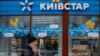 A woman walks past a store of Ukraine's telecommunications company Kyivstar, amid Russia's attacks on Ukraine, in Kyiv, Dec. 12, 2023.