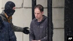 Репортера Wall Street Journal Эвана Гершковича выводят из суда после слушания в Москве, 26 января 2024 года.