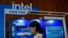 FILE - A woman checks her smartphone near an Intel booth promoting Xeon chips during a tech summit in Beijing, Aug. 16, 2023. China will phase out use of microprocessors from Intel and AMD, the Financial Times reported March 24, 2024. 