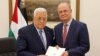 This handout picture provided by the Palestinian Authority's press office shows Palestinian President Mahmoud Abbas, left, with the newly appointed Palestinian prime minister, Mohammad Mustafa, in Ramallah on March 14, 2024. 
