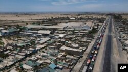 ARCHIVO - Los camiones están atascados en la carretera Panamericana debido a un bloqueo de carreteras por parte de manifestantes contra el gobierno y el Congreso de la presidenta Dina Boluarte en Ica, Perú, el viernes 6 de enero de 2023.