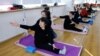 A teacher coaches an elderly person during a yoga class at Mama Sunset, a learning center for middle-aged and senior people in Beijing, China, Jan. 15, 2024.