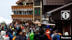 Pendaki dan pengunjung berkumpul pada hari pertama musim pendakian di Jalur Yoshidaguchidi stasiun kelima di lereng Gunung Fuji, di Fujiyoshida, Prefektur Yamanashi, Jepang, 1 Juli 2024. (Foto: Reuters)