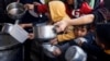 FILE - Palestinians wait to receive food cooked by a charity kitchen amid shortages of food supplies, as the conflict between Israel and the Palestinian Islamist group Hamas continues in Rafah in the southern Gaza Strip, March 5, 2024. 