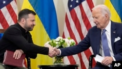 ARCHIVO - El presidente Joe Biden estrecha la mano del presidente ucraniano Volodymyr Zelenskyy en París, el 7 de junio de 2024.