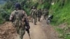 ARCHIVO - Soldados montan guardia cerca de los vagones de tren cargados de carbón, antes de que los indígenas wayuu de las comunidades cercanas levantaran un bloqueo de una línea férrea en Puerto Bolívar, Colombia, el 7 de abril de 2023.