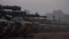 Israeli soldiers stand on top of a tank in a staging area at the Israeli-Gaza border in southern Israel, Jan. 1, 2024.