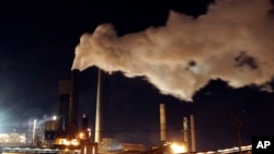 FILE - Steam bellows from a chimney stack at BlueScope Steel's steelworks at Port Kembla, south of Sydney, Australia. 