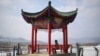 A woman sitting on a bench looking at Chunggang County North Korea in Linjiang in the province of Jilin, northeast China, Feb. 29, 2024.