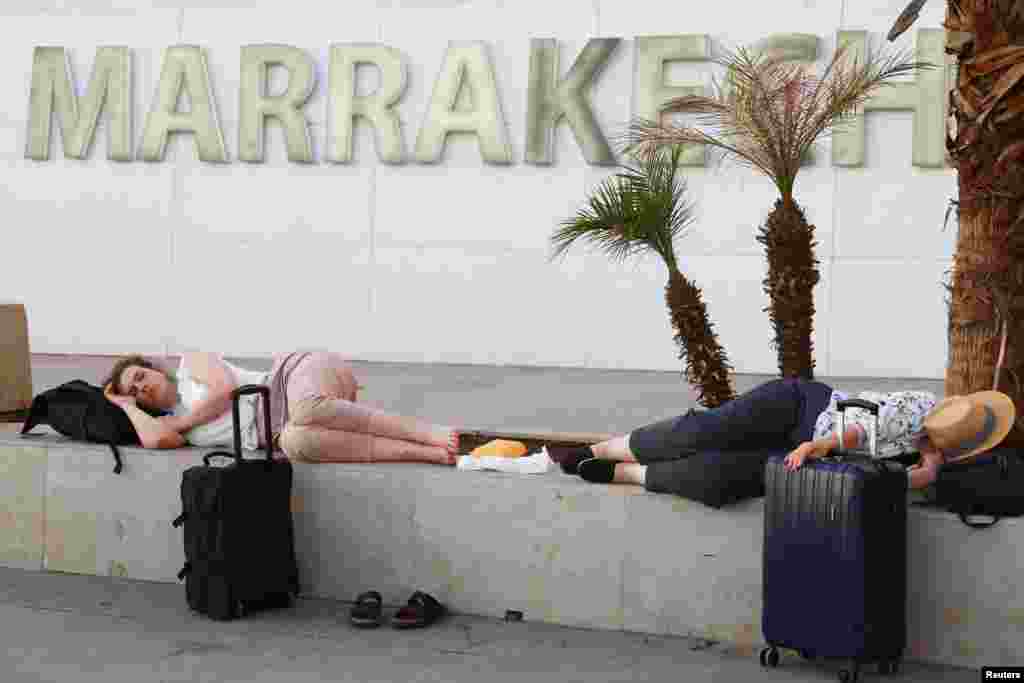 A las afueras del aeropuerto de Marrakech-Menara, personas descansan a la espera de sus vuelos tras el fuerte terremoto.&nbsp;