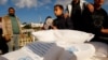 FILE - Palestinians receive sacks of flour distributed by the U.N.’s Palestinian relief agency UNRWA, in Rafah, in the southern Gaza Strip, Nov. 21, 2023.