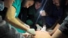Medical services use phone flashlights to assist a Palestinian wounded in Israeli strikes at the Indonesian hospital after Al Shifa hospital has gone out of service amid Israeli ground offensive, in the northern Gaza Strip, Nov. 16, 2023.
