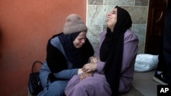 Palestinians mourn relatives killed in the Israeli bombardment of the Gaza Strip outside a morgue in Khan Younis, Jan. 4, 2024.