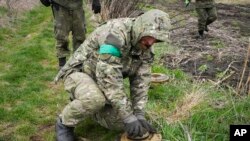 Український сапер знешкоджує протитанкову міну в місті Ірпінь біля Києва 19 квітня 2022 р.