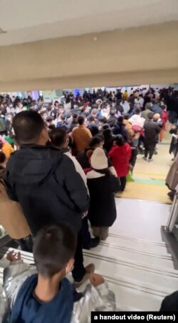 视频截图显示北京西城区儿童医院候诊室里挤满了等候看病的儿童和家长。（2023年11月27日）