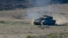 Israeli soldiers operate a tank near Gaza, after a temporary truce between Israel and the Palestinian Islamist group Hamas expired, as seen from southern Israel, December 2, 2023.