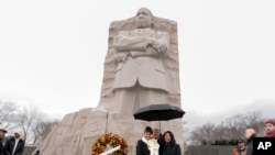 Martin Luther King III (tengah), ditemani putrinya Yolanda Reneee King (kiri), dan istrinya Andrea Waters King, berpose di Martin Luther King Jr. Memorial. Washington, D.C., Senin, 15 Januari 2024. (AP/Jose Luis Magana)