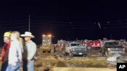 En esta imagen tomada de un video proporcionado por KAMC/KLBK, personas observan los escombros en Matador, Texas, el miércoles 21 de junio de 2023, luego de que las tormentas atravesaran el área.