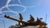 Israeli troops stand atop a tank on the border with the Gaza Strip on Nov. 30, 2023, on the seventh day of a truce in battles between Israel and Hamas militants.